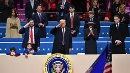 Didampingi Wakil Presiden Amerika Serikat JD Vance (kiri) dan Presiden Donald Trump memberi hormat saat parade perdana di dalam Capital One Arena, Washington DC. (ANGELA WEISS/AFP)