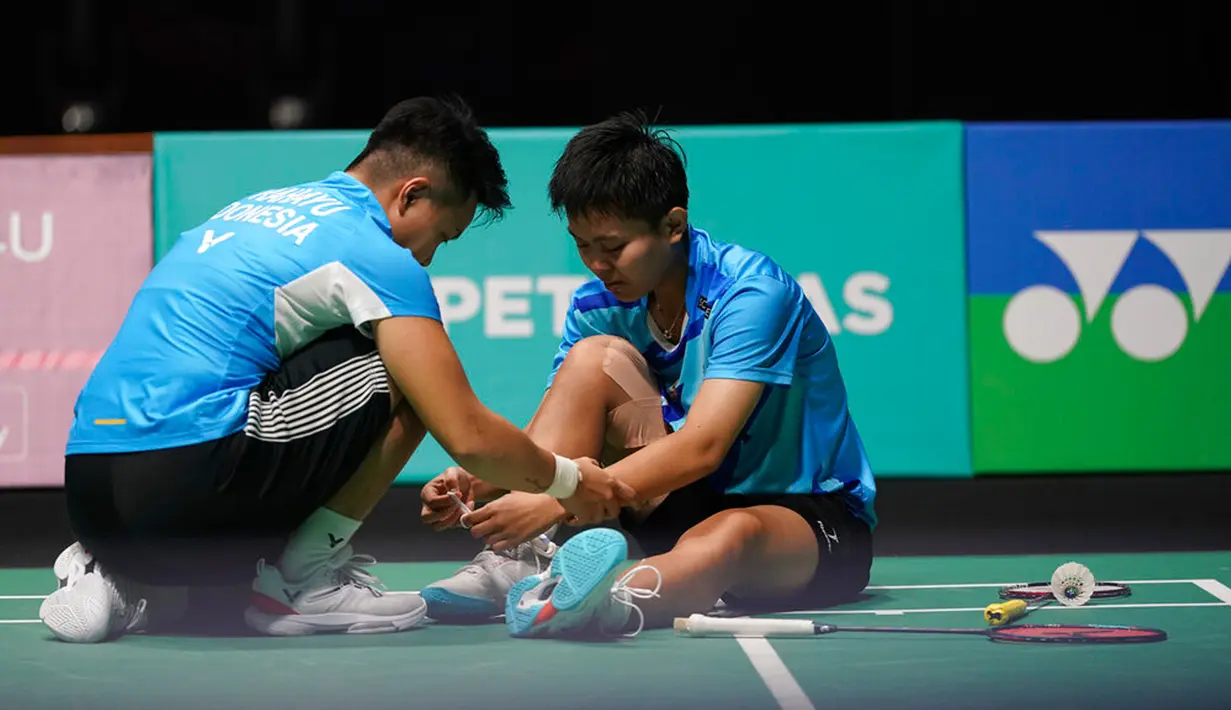 Reaksi Apriyani Rahayu (kiri) membantu Siti Fadia Silva Ramadhanti saat memutuskan mundur melawan China Chen Qing Chen dan Jia Yi Fan pada pertandingan semifinal ganda putri turnamen bulu tangkis Malaysia Open 2023 di Bukit Jalil Axiata Arena, Kuala Lumpur, Malaysia, Sabtu (14/1/2023). Apriyani Rahayu/Siti Fadia Silva Ramadhanti gagal mengamankan tiket final Malaysia Open 2023 setelah sepakat untuk mengakhiri laga lebih dulu karena Fadia mengalami cedera. (AP Photo/Kien Huo)