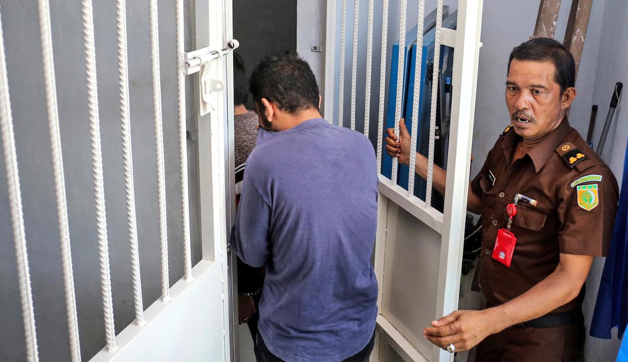 Petugas kantor kejaksaan mengawal dua orang terdakwa pasangan sejenis (gay) untuk menjalani persidangan di pengadilan syariah di Banda Aceh (17/5). (AP Photo/Heri Juanda)