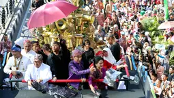 Presiden Joko Widodo (Jokowi) bersama Ibu Negara, Iriana Joko Widodo membagikan kaus dari atas kendaraan hias berbentuk kepala burung garuda pada Karnaval Kemerdekaan Pesona Parahyangan 2017 di Bandung, Sabtu (26/8). (Liputan6.com/Johan Tallo)