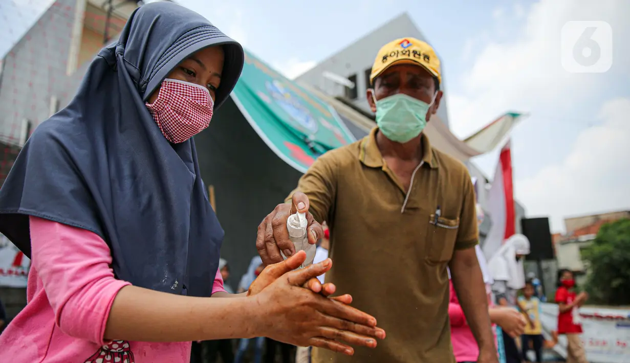Peserta menggunakan cairan hand sanitizer saat lomba menangkap belut dengan menerapkan protokol Kesehatan di kawasan Pondok Cabe IV, Tangerang Selatan, Senin (17/8/2020). Lomba tersebut digelar untuk menyemarakkan HUT ke-75 Kemerdekaan Republik Indonesia. (merdeka.com/Faizal Fanani)