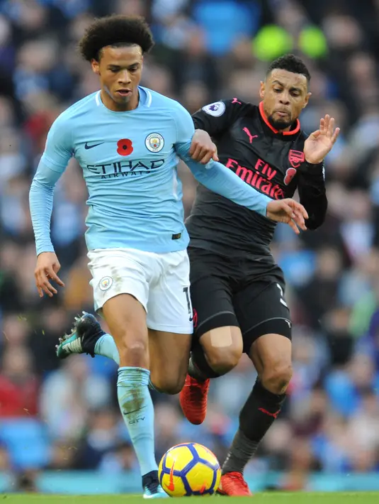 Gelandang Manchester City, Leroy Sane berusaha membawa bola dari kejaran pemain Arsenal, Francis Coquelin saat bertanding pada lanjutan Liga Inggris di di Stadion Etihad, Inggris, (5/11). City menang atas Arsenal dengan skor 3-1. (AP Photo / Rui Vieira)