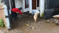 Tim relawan membantu membersihkan rumah warga dii Teluk Bayur, Kota Malang, yang terendam lumpur karena dampak banjir yang terjadi pada Senin, 14 Maret 2022 (Liputan6.com/Zainul Arifin)