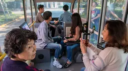 Sejumlah penumpang menaiki minibus tanpa awak di Shanghai Jiao Tong University di Shanghai, China (8/5). Beberapa fitur terbaru seperti hemat energi, dan manufaktur dengan kualitas terbaik, melekat pada bus. (AFP Photo/China Out)
