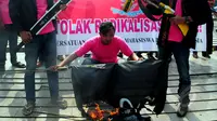 Sejumlah mahasiswa melakukan aksi menolak ISIS di Car Free Day, Bundaran HI, Jakarta, Minggu (15/3/2015). Mereka melakukan aksi teaterikal sebagai bentuk sindiran terhadap kekejaman ISIS. (Liputan6.com/Yoppy Renato) 