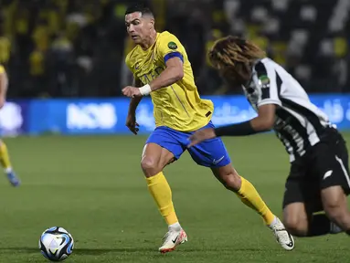 Pemain Al-Nassr, Cristiano Ronaldo (tengah) berusaha melewati pemain Al Shabab, Fawaz Al-Sagour pada laga perempat final Piala Raja Arab Saudi 2023 di Al-Shabab Club Stadium, Riyadh, Arab Saudi, 12 Desember 2023 WIB. (AFP/STR)