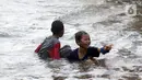 Anak-anak bermain di genangan air akibat banjir rob di kawasan pintu masuk Pelabuhan Nizam Zachman, Muara Baru, Jakarta, Jumat (5/6/2020). Banjir rob di Pelabuhan Muara Baru tersebut terjadi akibat cuaca ekstrem serta pasang air laut. (Liputan6.com/Helmi Fithriansyah)