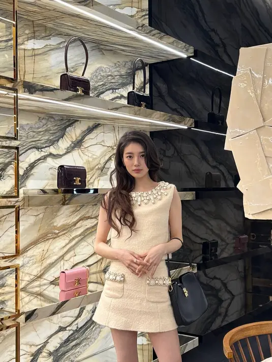 Bae Suzy tampil mengenakan setelan atasan sleeveless dan rok mini tweed berdetail beads yang cantik. [@skuukzky]