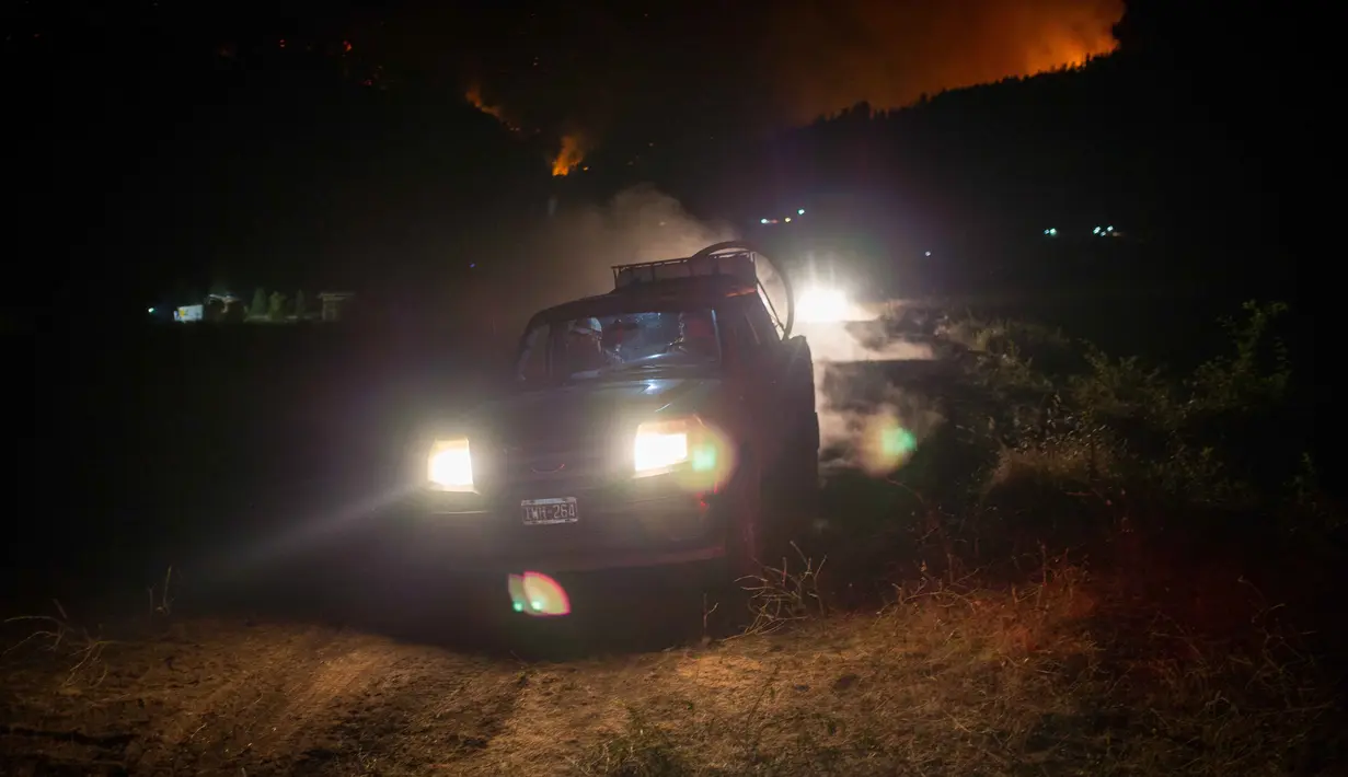 Lebih dari 3.000 wisatawan dari resor tepi danau Puerto Patriada, bersama beberapa penduduk telah dievakuasi ke lokasi yang lebih aman. Tampak dalam foto, orang-orang tiba dengan truk air saat kebakaran hutan berkobar di Gunung Pirque, El Hoyo, wilayah Patagonia provinsi Chubut, Argentina pada 7 Januari 2026. (Martin LEVICOY/AFP)