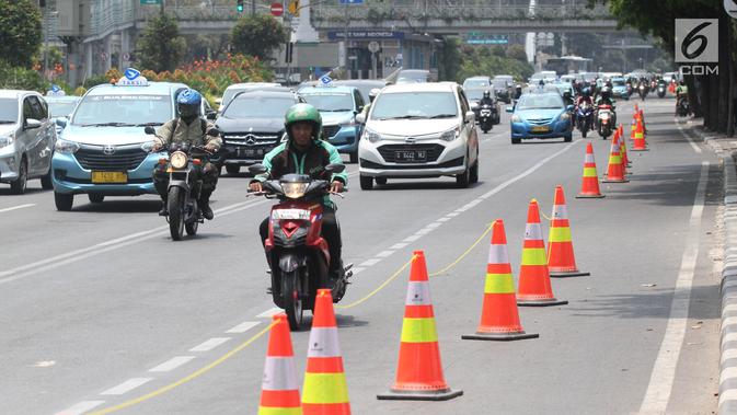 Pengendara sepeda motor melintasi di samping jalur sepeda di Jalan MH Thamrin, Jakarta, Selasa (24/9/2019). Jalur sepeda tersebut sedang dalam masa uji coba mulai 20 September hingga 19 November 2019. (Liputan6.com/Herman Zakharia)