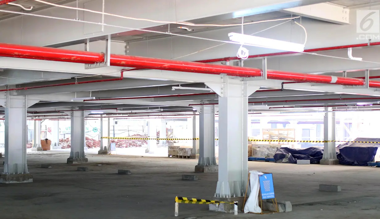 Pekerja tengah menyelesaikan pembagunan gedung parkir di Gelora Bung Karno (GBK) Senayan, Jakarta, Jumat (11/5). Gedung parkir bertingkat itu akan menambah kapasitas sekitar 1.300 kendaraan. (Liputan6.com/Angga Yuniar)