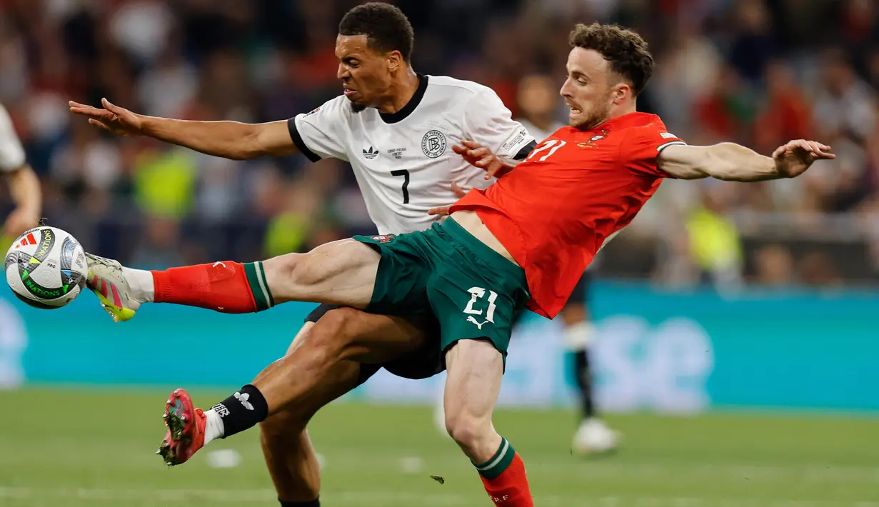 Federasi Sepak Bola Portugal (FPF) menyebut Diogo Jota sebagai sosok yang luar biasa. Presiden FPF Pedro Proenca menyampaikan ucapan duka cita atas musibah yang dialami Diogo Jota dan sang adik, Andre Silva. Keduanya meninggal dunia akibat kecelakaan mobil. Tampak dalam foto, penyerang Portugal Diogo Jota (kanan) berebut bola dengan Felix Nmecha (Jerman) saat pertandingan sepak bola semifinal UEFA Nations League di Munich, Jerman pada 4 Juni 2025. (Alexandra BEIER/AFP)