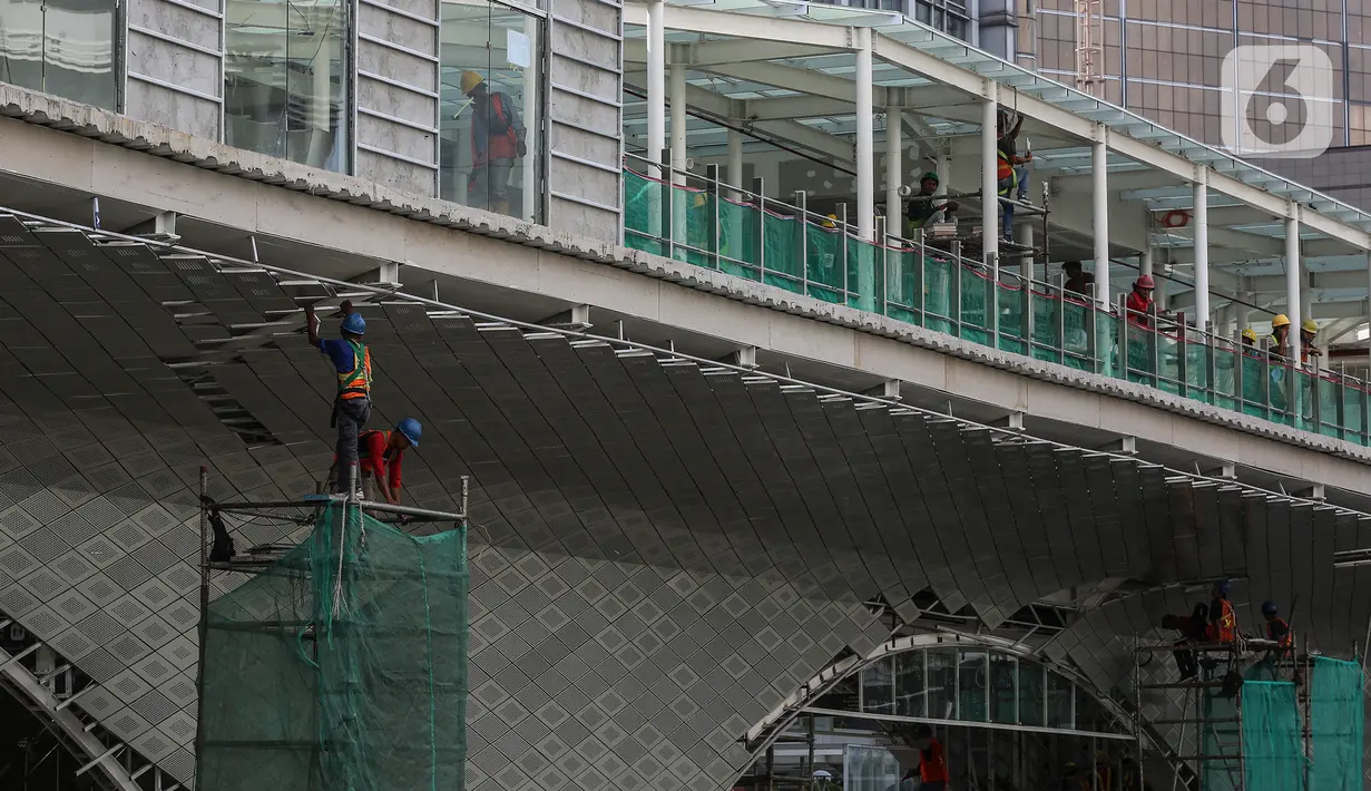Pekerja menyelesaikan proyek pembangunan Halte TransJakarta di Hotel Indonesia, Jakarta, Jumat (30/9/2022).  JJ Rizal yang juga sebagai Anggota TSP itu meminta agar pembangunan halte yang digadang-gadang ikonik itu untuk dihentikan. (Liputan6.com/Johan Tallo)