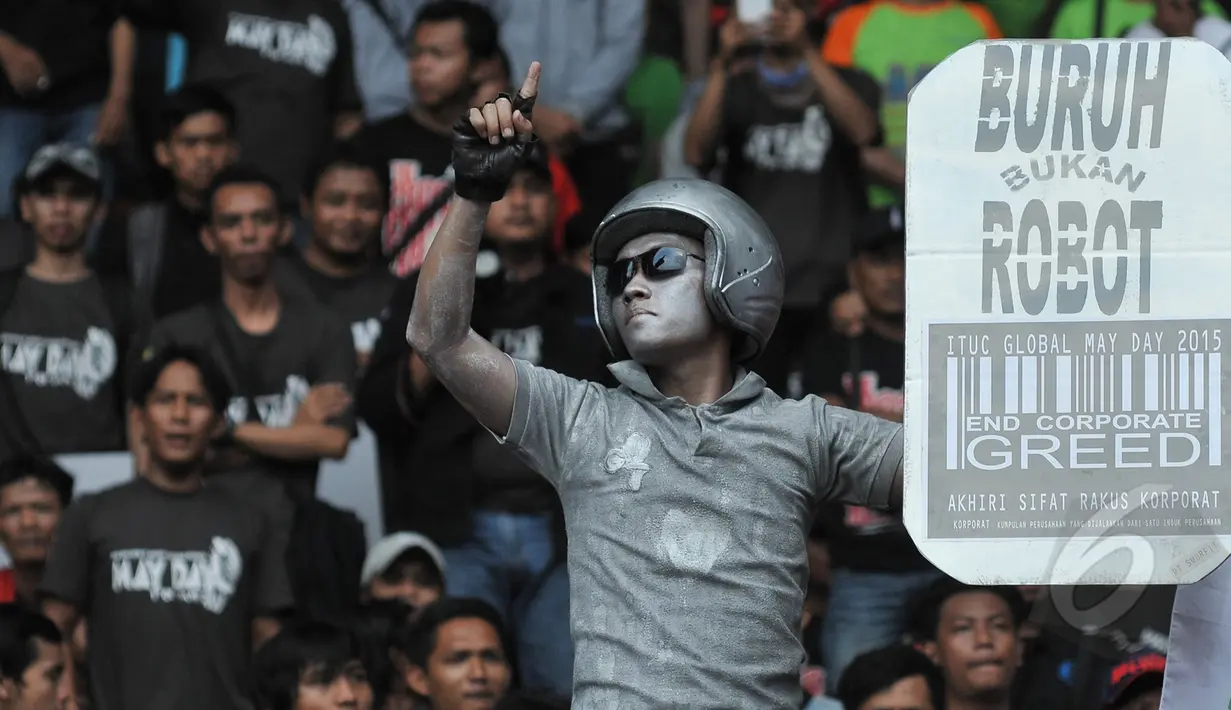 Seorang buruh mengecat tubuhnya sebagai sindiran saat perayaan hari buruh sedunia (May Day), SGBK, Jakarta, Jumat (1/5/2015). Mereka menuntut melawan kebijakan upah murah dan kenaikan upah setiap lima tahun sekali. (Liputan6.com/Herman Zakharia)