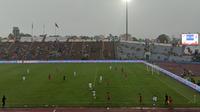 Sejumlah suporter Timnas Indonesia U-23 dalam partai kontra Myanmar tetap berdiri dan bernyanyi meski hujan deras mengguyur Viet Tri Stadium, Viet Tri, Provinsi Phu Tho pada Minggu (15/5/2022) sore waktu setempat. (Bola.com/Muhammad Adiyaksa)