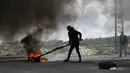 Pengunjuk rasa Palestina membakar ban saat bentrokan dengan pasukan Israel di pinggiran Kota Ramallah, Tepi Barat, Rabu (27/3). Bentrokan ini sebagai bentuk protes terhadap tahanan Palestina yang berada di Israel. (AP Photo/Majdi Mohammed)