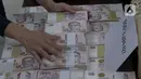 Petugas menata barang bukti terkait penangkapan mantan pejabat Mahkamah Agung Zarof Ricar di gedung Kejaksaan Agung, Jakarta, Jumat (25/10/2024). (Liputan6.com/Herman Zakharia)