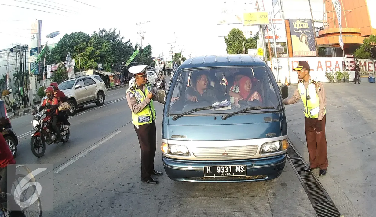 Petugas Kepolisian memberhentikan pengendara mobil di Simpang Maya, Tegal, Jawa Tengah Minggu (10/7). Pemberhentian dilakukan untuk mengecek muatan mobil agar aman saat berlalu lintas. (Liputan6.com/Herman Zakharia)