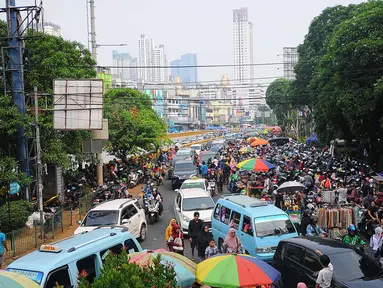 Sejumlah mobil terjebak kemacetan di kawasan Tanah Abang, Jakarta, Minggu (26/5/2019). Banyaknya masyarakat yang berbelanja di pasar tanah abang membuat arus lalu lintas di kawasan tersebut padat. (Liputan6.com/Angga Yuniar)