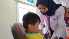 Petugas medis memeriksa seorang anak yang berobat ke Rail Clinic yang berhenti di Stasiun Alastua, Semarang, Jawa Tengah, Kamis ( 28/3). Pengobatan gratis dari PT KAI ini dihadiri oleh ratusan warga sekitar stasiun. (Liputan6.com/Gholib)