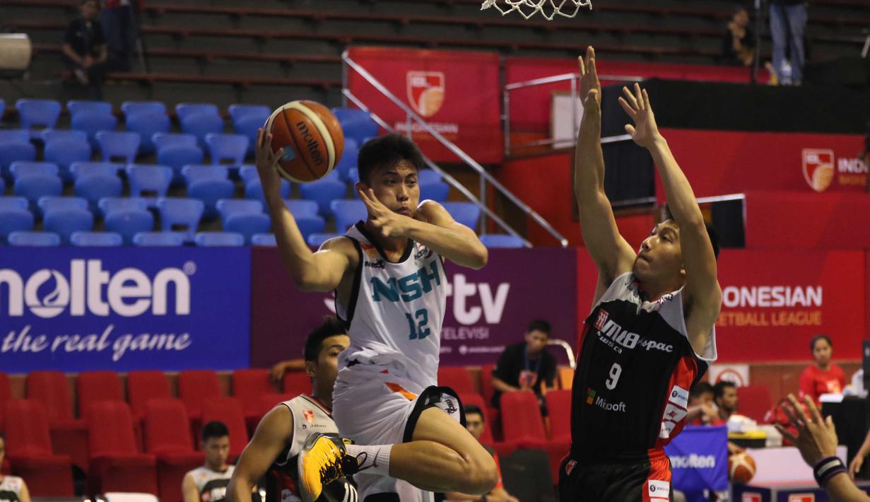 Pemain NSH Jakarta, Yoseph Wijaya melakukan Lay Up saat dihadang pemain M88 Aspac Jakarta, Handri Santoso pada laga IBL Reguler Season di Hall A Senayan, Jakarta, Minggu (10/1/2016). Aspac Jakarta menang 78-61. (Bola.com/Nicklas Hanoatubun)
