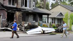 Pejabat Federal Aviation Administration menyelidiki lokasi pesawat yang sengaja menabrak rumah di Payson, Utah, AS, Senin (13/8). Istri dan putra sang putra yang berada di dalam rumah dapat menyelamatkan diri. (Scott G Winterton/The Deseret News via AP)