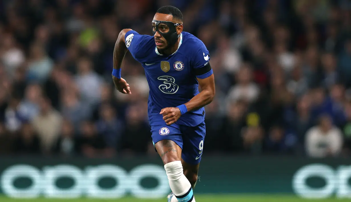 Pierre-Emerick Aubameyang. Striker Gabon berusia 33 tahun yang baru saja bergabung dengan Chelsea di awal musim 2022/2023 ini langsung mengenakan topeng di laga pertamanya bersama Chelsea di matchday pertama fase grup Liga Champions menghadapi Dinamo Zagreb. Bukan lantaran cedera saat bertanding yang membuatnya harus mengenakan topeng, namun ia mengalami cedera patah di bagian rahang akibat peristiwa perampokan yang dialaminya bersama keluarga di Spanyol saat dirinya telah dipastikan akan hijrah ke Chelsea. (AFP/Adrian Dennis)