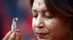 Seorang perempuan Hindu terlihat khusyuk berdoa di kuil Pashupatinath saat perayaan festival Teej di Kathmandu, (28/8/2014). (REUTERS/Navesh Chitrakar)