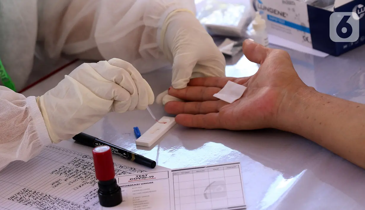 Petugas Medis mengambil sampel darah warga saat rapid test massal di Kota Tangerang, Banten, Sabtu (30/5/2020).  Badan Intelijen Negara (BIN) menggelar tes diagnostik cepat (rapid rest) massal kepada warga Ciledug sebagai salah satu upaya pengendalian transmisi COVID-19. (Liputan6.com/Angga Yuniar)