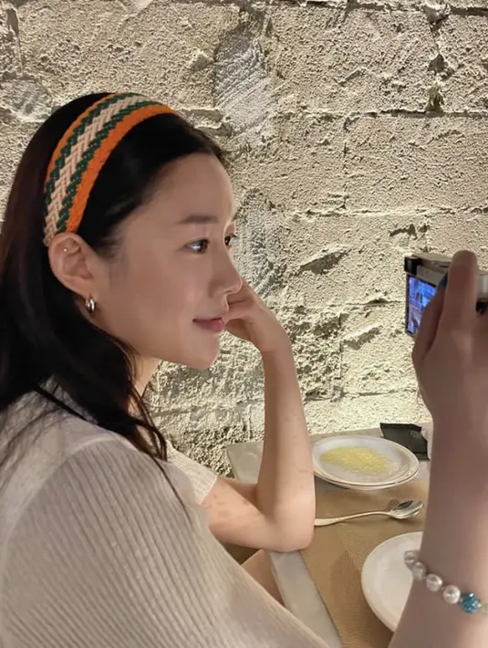 Rambut panjangnya pun dihiasi bandana warna orange. Ia tampak tampil dengan riasan no makeup.(@xx__dain)