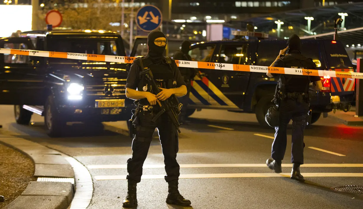 Pihak keamanan Belanda berjaga di area Bandara Internasional Schiphol, Amsterdam, yang ditutup menyusul ancaman bom, Selasa (12/4).  Pihak kepolisian menangkap seorang pria dengan perilaku mencurigakan terkait ancaman bom. (Michel van Bergen/ANP/AFP)