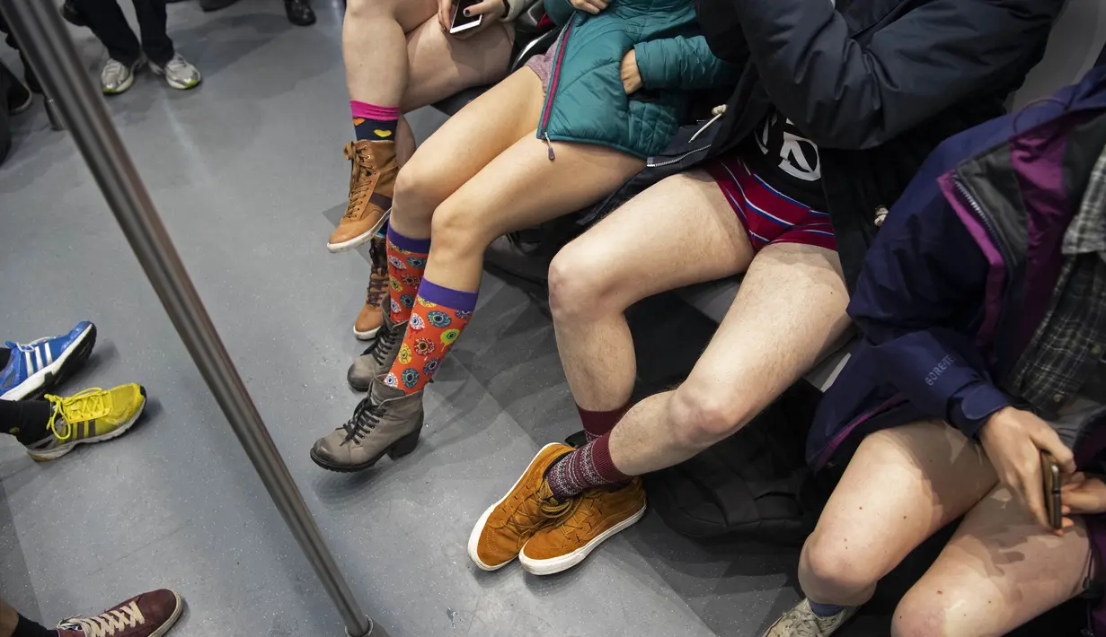 Sejumlah penumpang tanpa mengenakan celana duduk di kereta selama No Pants Subway Ride ke-18 di Amsterdam, Belanda (13/1). No Pants Subway Ride ajang tahunan yang sudah menyebar ke berbagai kota besar di dunia. (AFP Photo/Olaf Kraak)
