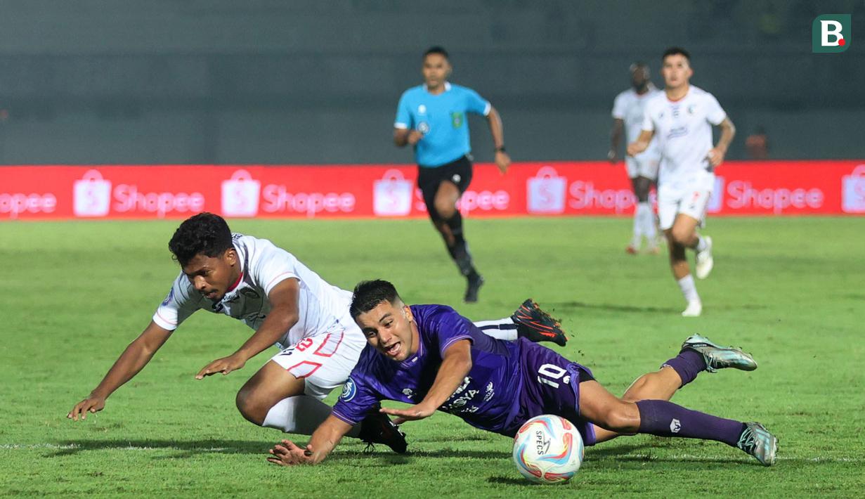 Pemain Persita Tangerang, Ezequiel Vidal, terjatuh saat berebut bola dengan pemain Arema FC, Rifad Marasabessy, pada laga BRI Liga 1 di Stadion Indomilk Arena, Tangerang, Rabu (13/3/2024). (Bola.com/M. Iqbal Ichsan)