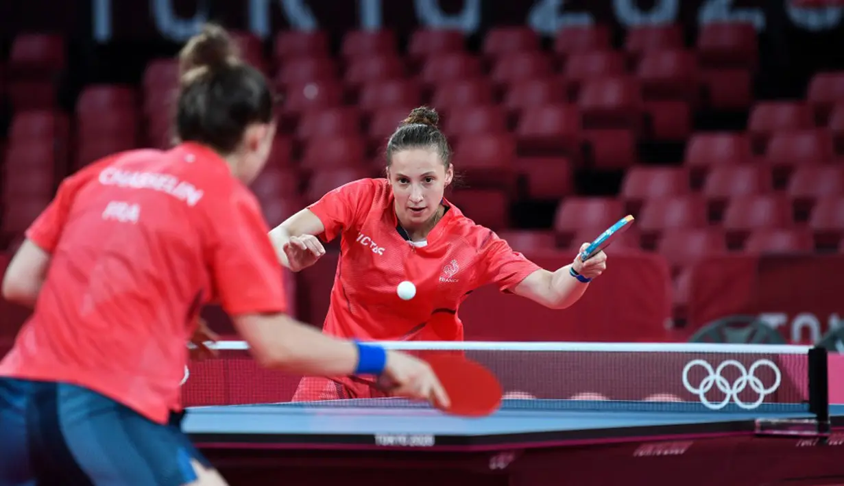 Pemain tenis meja Prancis Stephanie Loeuillette (kanan) mengembalikan bola kepada rekan setimnya Pauline Chasselin saat sesi latihan jelang Olimpiade Tokyo 2020 di Tokyo Metropolitan Gymnasium, Tokyo, Jepang, Rabu (21/7/2021). Olimpiade Tokyo 2020 akan dibuka pada 23 Juli 2021. (Jung Yeon-je/AFP)