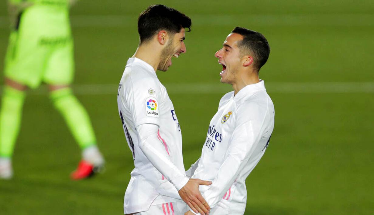 Gelandang Real Madrid, Marco Asensio, melakukan selebrasi bersama Lucas Vazquez usai mencetak gol ke gawang Celta Vigo pada laga Liga Spanyol di Stadion Alfredo Di Stefano, Sabtu (2/1/2021). Real Madrid menang dengan skor 2-0. (AP/Manu Fernandez)