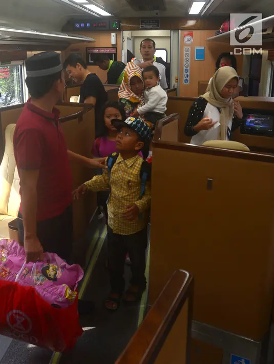 Pemudik bersiap menaiki  kereta sleeper di Stasiun Gambir, Jakarta, Selasa (12/6). Fasilitas yang tersedia seperti kursi yang dapat direbahkan 170, sandaran kaki elektrik, private entertainment hingga foldable food tray. (Merdeka.com/Imam Buhori)