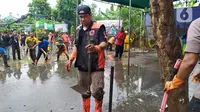 Gubernur DKI Jakarta Anies Baswedan ikut kerja bakti usai banjir di Makassar Jakarta Timur. (Ika Defianti/Liputan6.com)