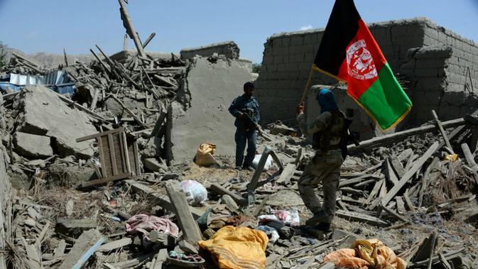 Seorang tentara nasional Afghanistan memegang bendera resmi negara tersebut (AFP Photo)
