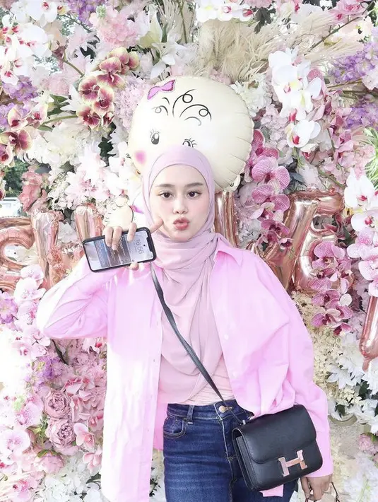 Jika ingin tampil kasual saat hari Valentine, bisa mencontek gaya Lesti Kejora ini. Ia mengenakan kemeja oversize pink dengan inner dan kerudung warna pink yang lebih soft. Cukup padukan dengan denim dan handbag hitam.  (@lestykejora)