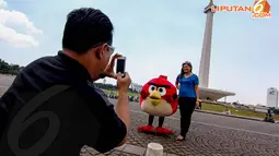 Seorang wanita tampak berpose dengan badut boneka Angry Bird yang sengaja   mangkal untuk menghibur pengunjung (Liputan6.com/Faizal Fanani)