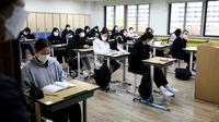 Siswa mengikuti ujian masuk perguruan tinggi tahunan di sebuah sekolah di Seoul, Korea Selatan, Kamis (18/11/2021). Bagi warga negara Korea Selatan, ujian masuk perguruan tinggi dianggap sebagai hal yang sangat penting. (Chung Sung-Jun/POOL/AFP)
