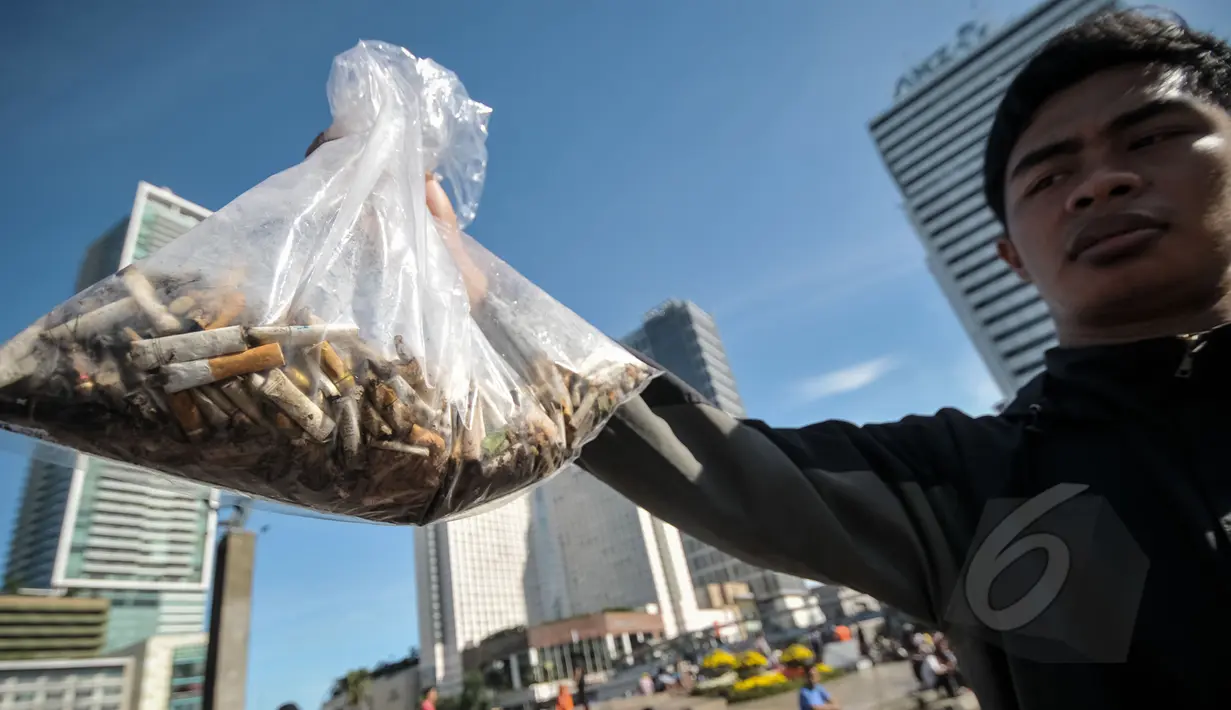 Seorang aktivis menunjukkan puntung rokok yang berhasil dikumpulkan saat Aksi Selamatkan Bumi dari Limbah Puntung Rokok di kawasan Bundaran HI, Jakarta, Minggu (26/4/2015). Kegiatan tersebut untuk memperingati Hari Bumi. (Liputan6.com/Faial Fanani)
