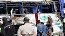 Petugas penyelamat berkumpul di sebuah bus pembawa turis asal Kolombia dan Venezuela yang terlibat kecelakaan di Pifo, Ekuador, Selasa (14/8). Bus menabrak sebuah kendaraan dan terbalik, lalu menghantam tiga rumah di sisi jalan. (AP Photo/Carlos Noriega)