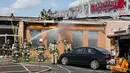 Petugas memadamkan bara api usai pesawat kecil menabrak gedung dekat Bandara Teterboro di luar Kota New York, Senin (15/5). Saat pendaratan, pesawat tergelincir dan keluar landasan pacu sekkitar 400 meter. (Aristide Economopoulos/NJ Advance Media via AP)