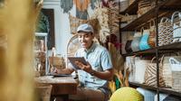 Ilustrasi seorang pria sedang melakukan transaksi toko online miliknya. (Foto: Shutterstock)