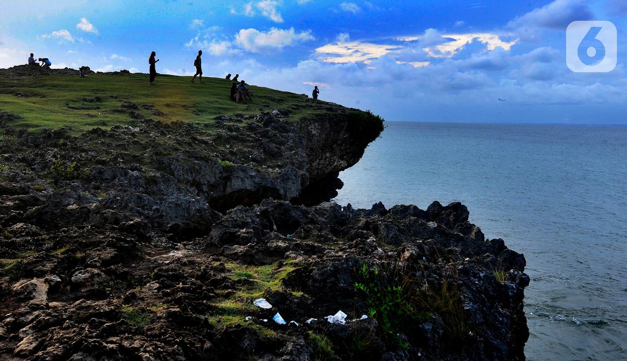 Wisatawan menunggu senja di Pantai Honeymoon di kawasan Jimbaran, Bali, Rabu (26/4/2023). (merdeka.com/Arie Basuki)