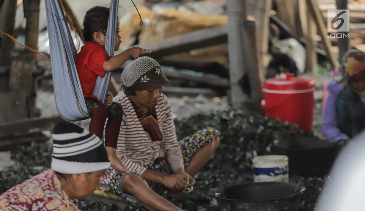Seorang anak ikut menemani ibunya mengupas kerang hijau di Kampung Nelayan Muara Angke, Jakarta, Rabu (3/7/2019). Dengan penghasilan rata-rata Rp 30 ribu/hari, para buruh pengupas kerang hijau tersebut harus cukup memenuhi kebutuhan hidup keluarganya. (Liputan6.com/Faizal Fanani)