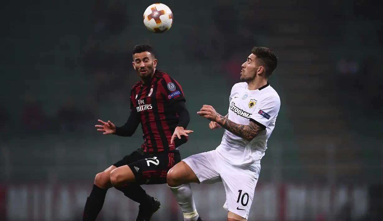 Bek AC Milan, Mateo Musacchio, duel udara dengan striker AEK Athens, Marko Livaja, pada laga Liga Europa di Stadion San Siro, Milan,  Kamis (19/10/2017). AC Milan bermain imbang 0-0 dengan AEK Athens. (AFP/Marco Bertorello)