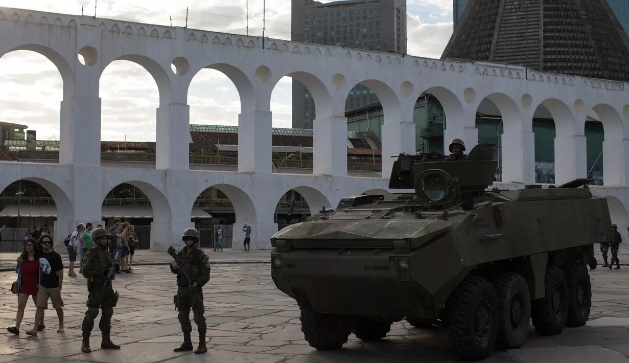 Sebuah mobil baja terlihat saat patroli di lingkungan Lapa di Rio de Janeiro, Brasil, (30/7). Ribuan tentara mulai berpatroli di Rio de Janeiro di tengah lonjakan kekerasan di kota terbesar kedua di Brasil. (AP Photo / Leo Correa)