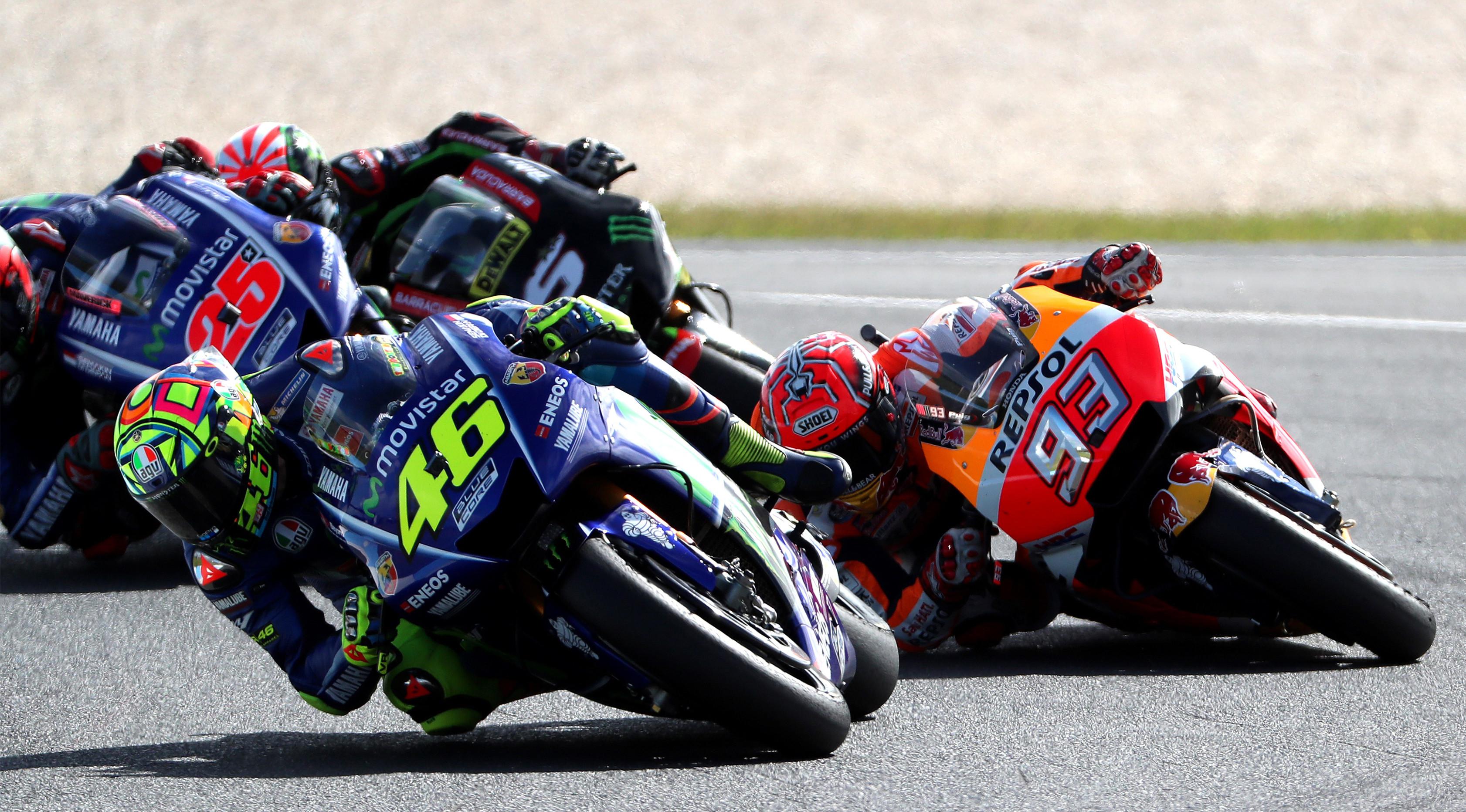 Marc Marquez (kedua) berduel dengan Valentino Rossi (depan) di sebuah lintasan MotoGP. (AFP Photo/Glenn Nicholls)